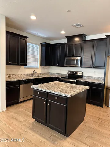 a kitchen with stainless steel appliances granite countertop a stove a sink and a microwave