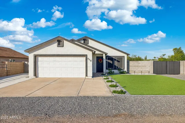 a front view of a house with a garden and yard
