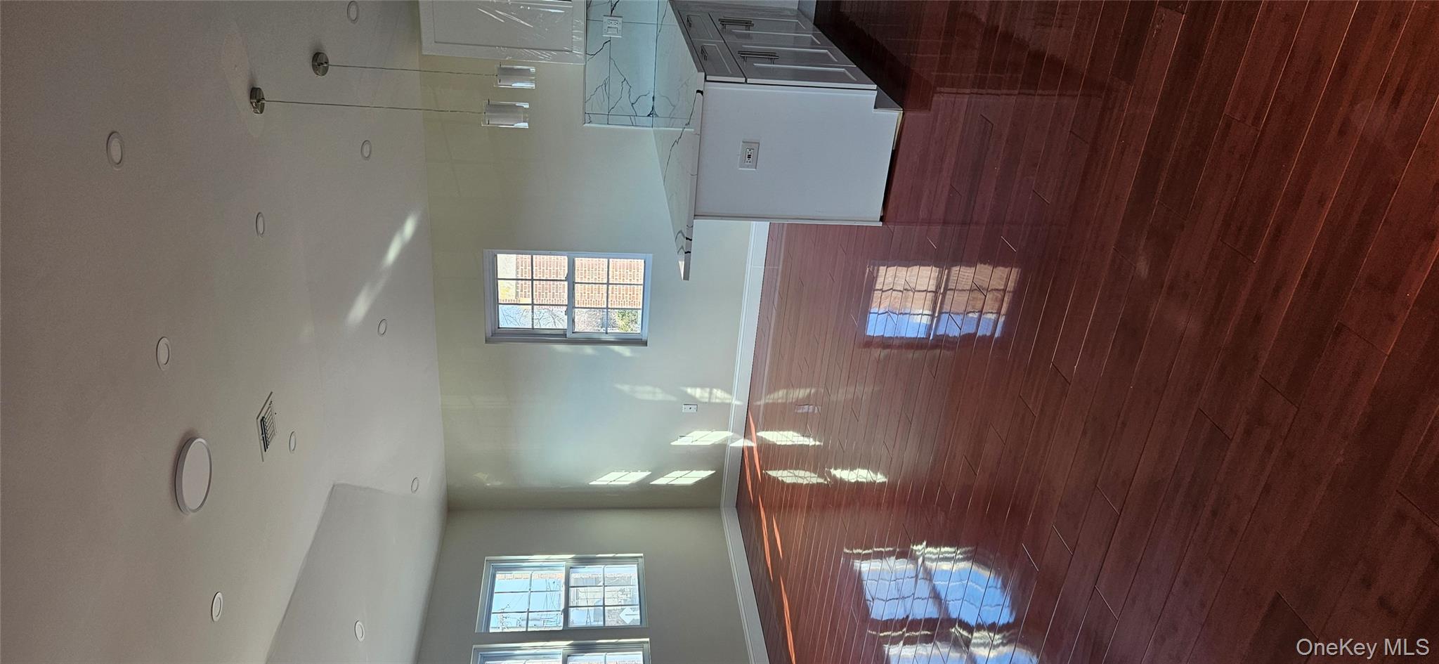 178-41 146th Terrace Queens, NY 11413 - Photo 16 of 23 a view of a kitchen with kitchen island a sink wooden floor and a large window