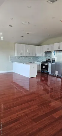a kitchen with kitchen island white cabinets and stainless steel appliances