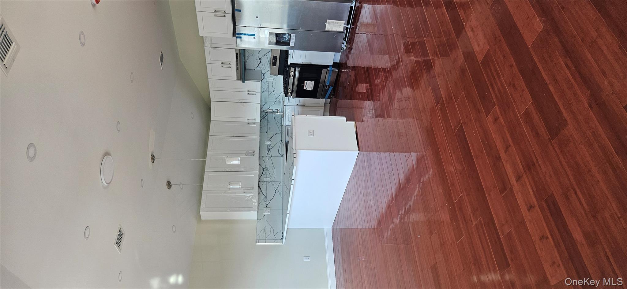 178-41 146th Terrace Queens, NY 11413 - Photo 17 of 23 a kitchen with stainless steel appliances wooden floors and view living room