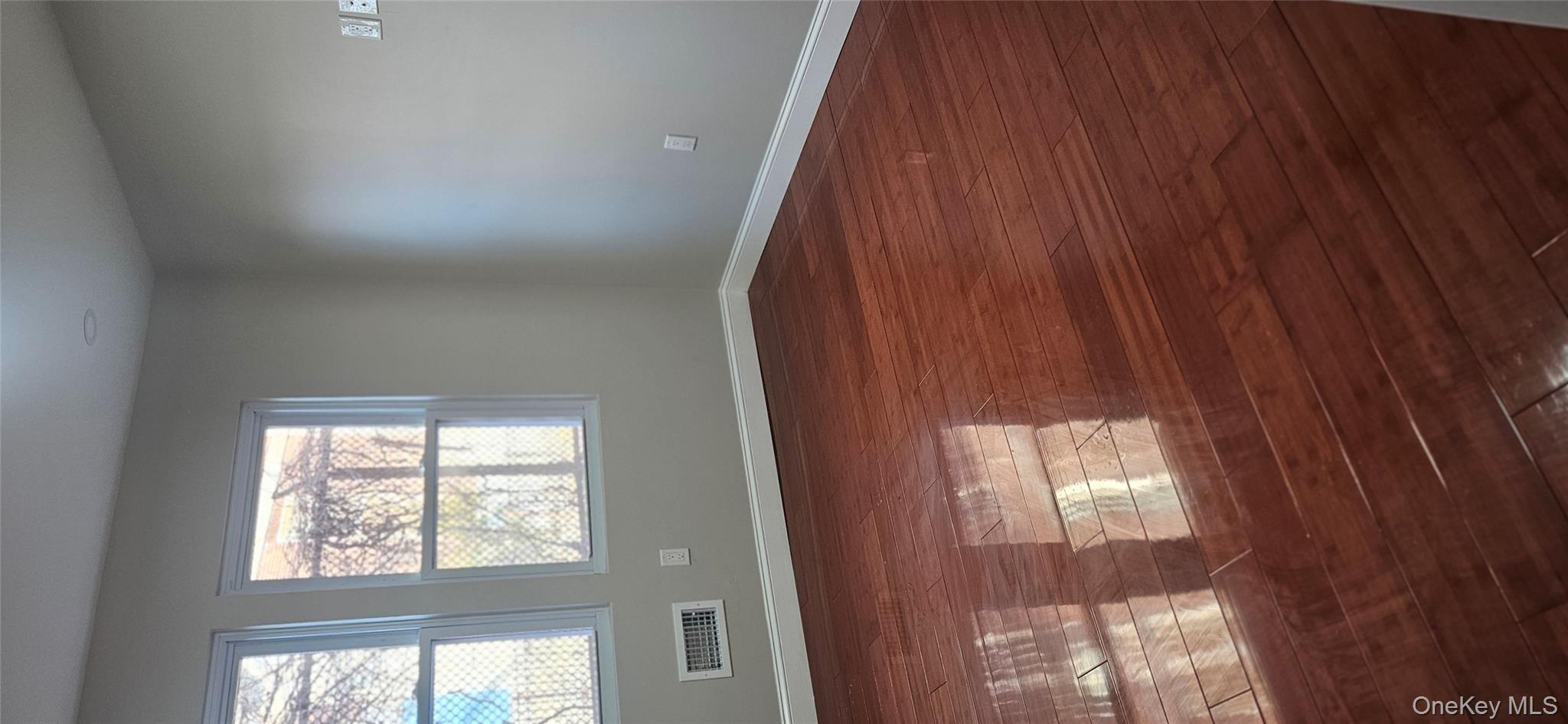 178-41 146th Terrace Queens, NY 11413 - Photo 5 of 23 an empty room with wooden floor and windows