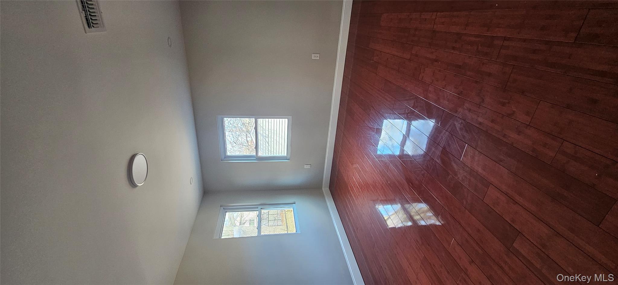 178-41 146th Terrace Queens, NY 11413 - Photo 8 of 23 an empty room with wooden floor and windows