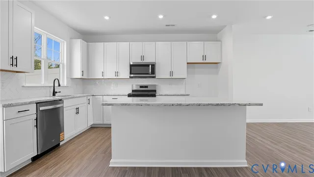 a kitchen with stainless steel appliances granite countertop a stove a sink and a microwave