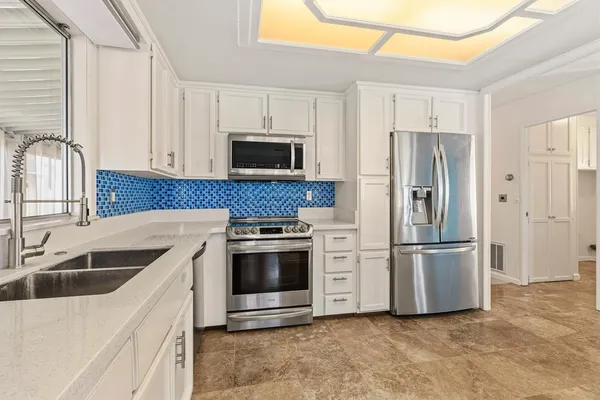 a kitchen with stainless steel appliances a refrigerator stove and microwave