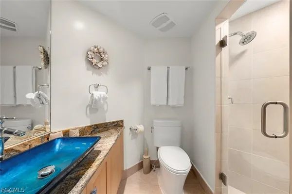 a bathroom with a granite countertop sink a toilet and a shower curtain
