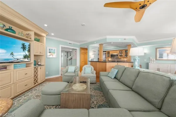 a living room with furniture white walls and kitchen view