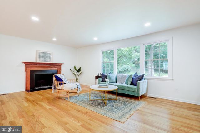 a living room with furniture and kitchen view with wooden floor