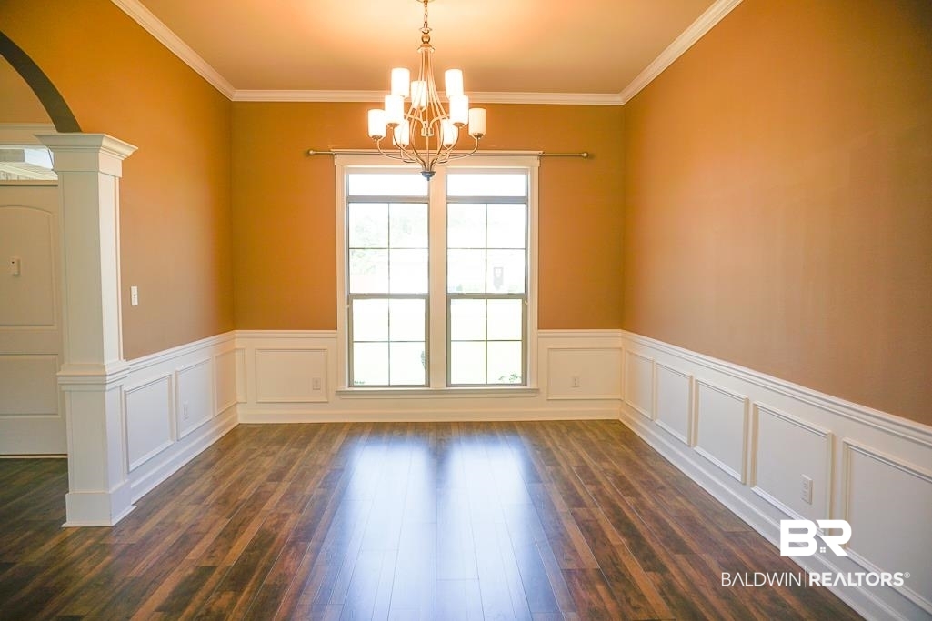 593 Begeman Road Mobile, AL 36608 - Photo 3 of 23 Empty room with a wealth of natural light, dark wood-type flooring, and ornate columns