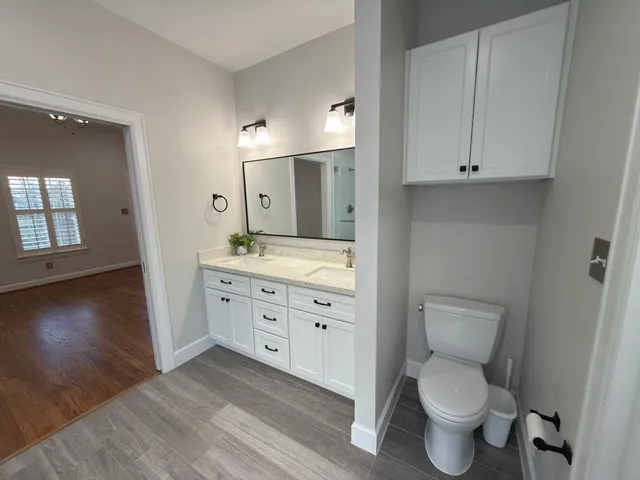 a spacious bathroom with a toilet sink and mirror