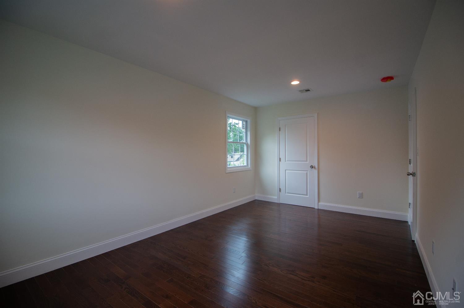 14 Caldwell Road Edison, NJ 08817 - Photo 21 of 22 a view of an empty room with wooden floor and a window