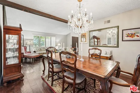 a view of a dining room with furniture a chandelier and wooden floor