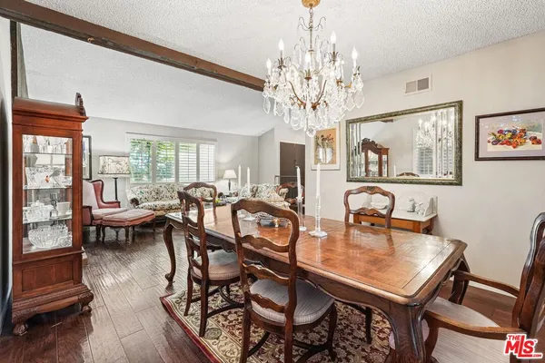a view of a dining room with furniture a chandelier and wooden floor