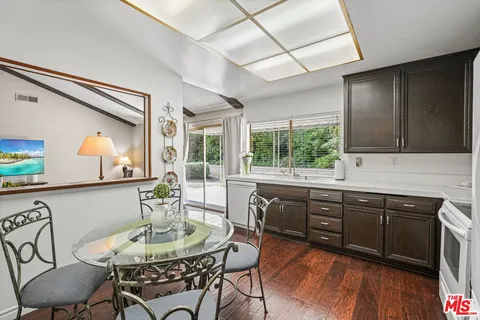 a kitchen with stainless steel appliances granite countertop a sink and wooden floor
