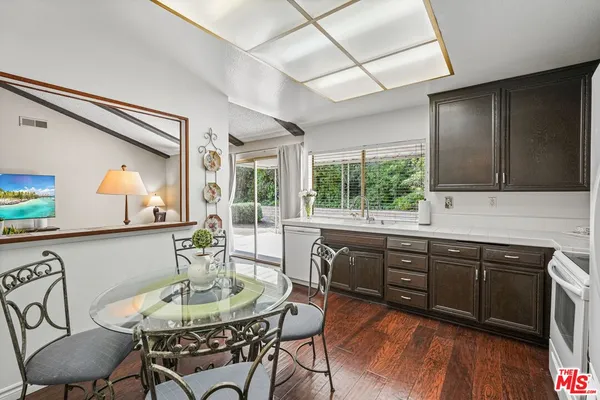 a kitchen with stainless steel appliances granite countertop a sink and wooden floor