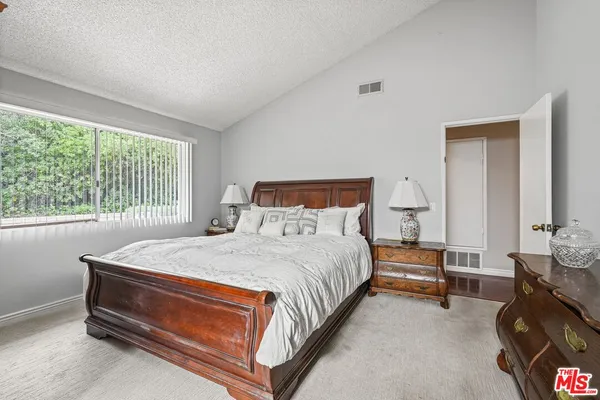 a bed sitting in a bedroom next to a window