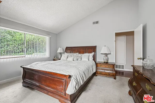 a bed sitting in a bedroom next to a window