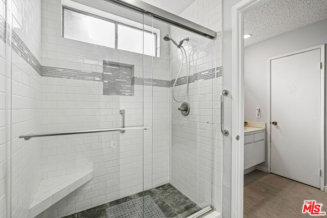10621 Vanalden Avenue Porter Ranch, CA 91326 - Photo 27 of 38 a bathroom with a glass shower door
