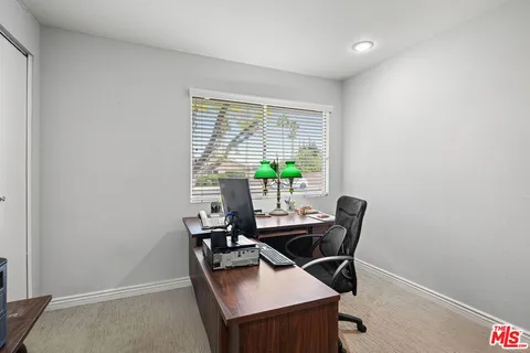 a view of a workspace with furniture and a window