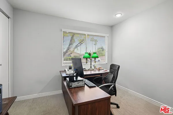 a view of a workspace with furniture and a window