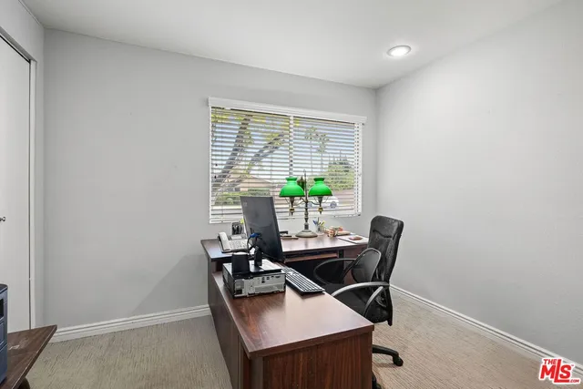 a view of a workspace with furniture and a window