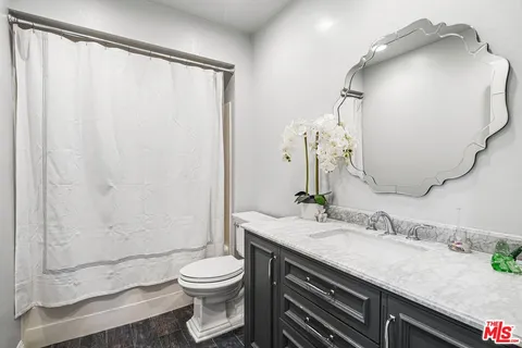 a bathroom with a granite countertop sink toilet and shower