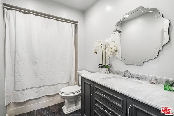 a bathroom with a granite countertop sink toilet and shower