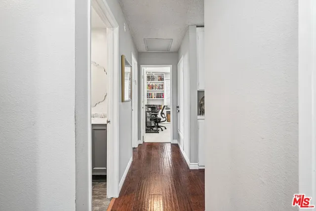 a view of a hallway with wooden floor and staircase