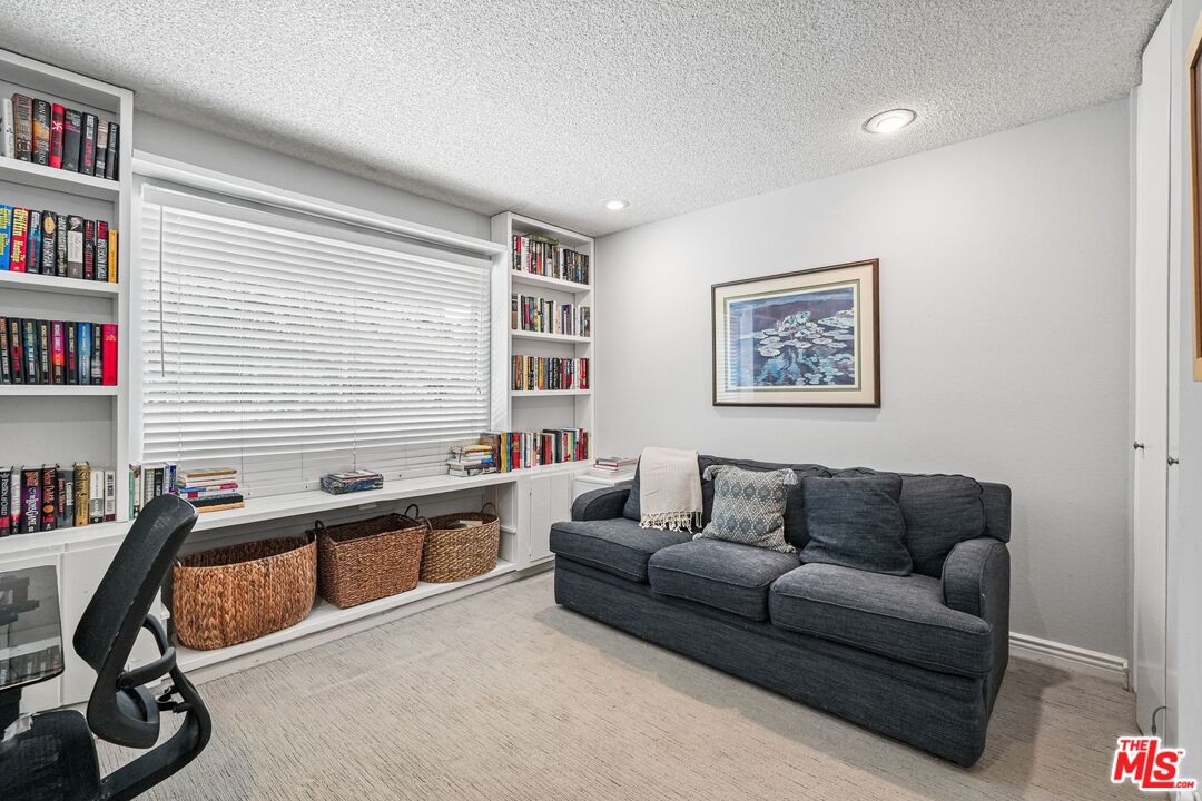10621 Vanalden Avenue Porter Ranch, CA 91326 - Photo 35 of 38 a living room with furniture a rug and a window
