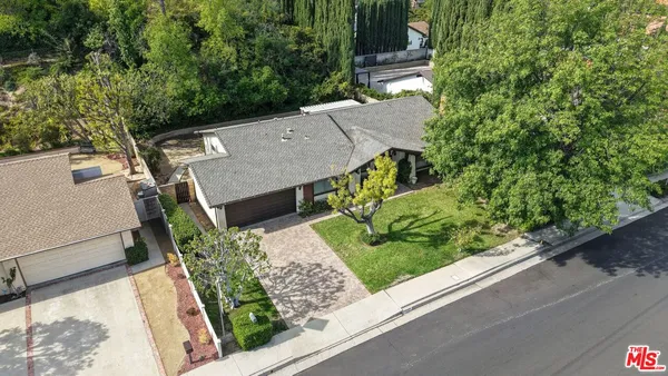 an aerial view of a house with a yard and potted plants