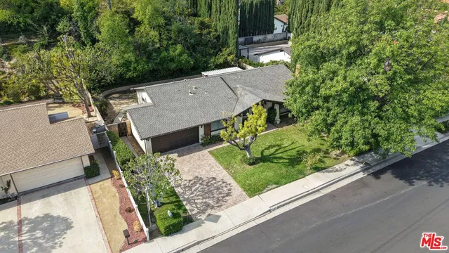 an aerial view of a house with a yard and potted plants