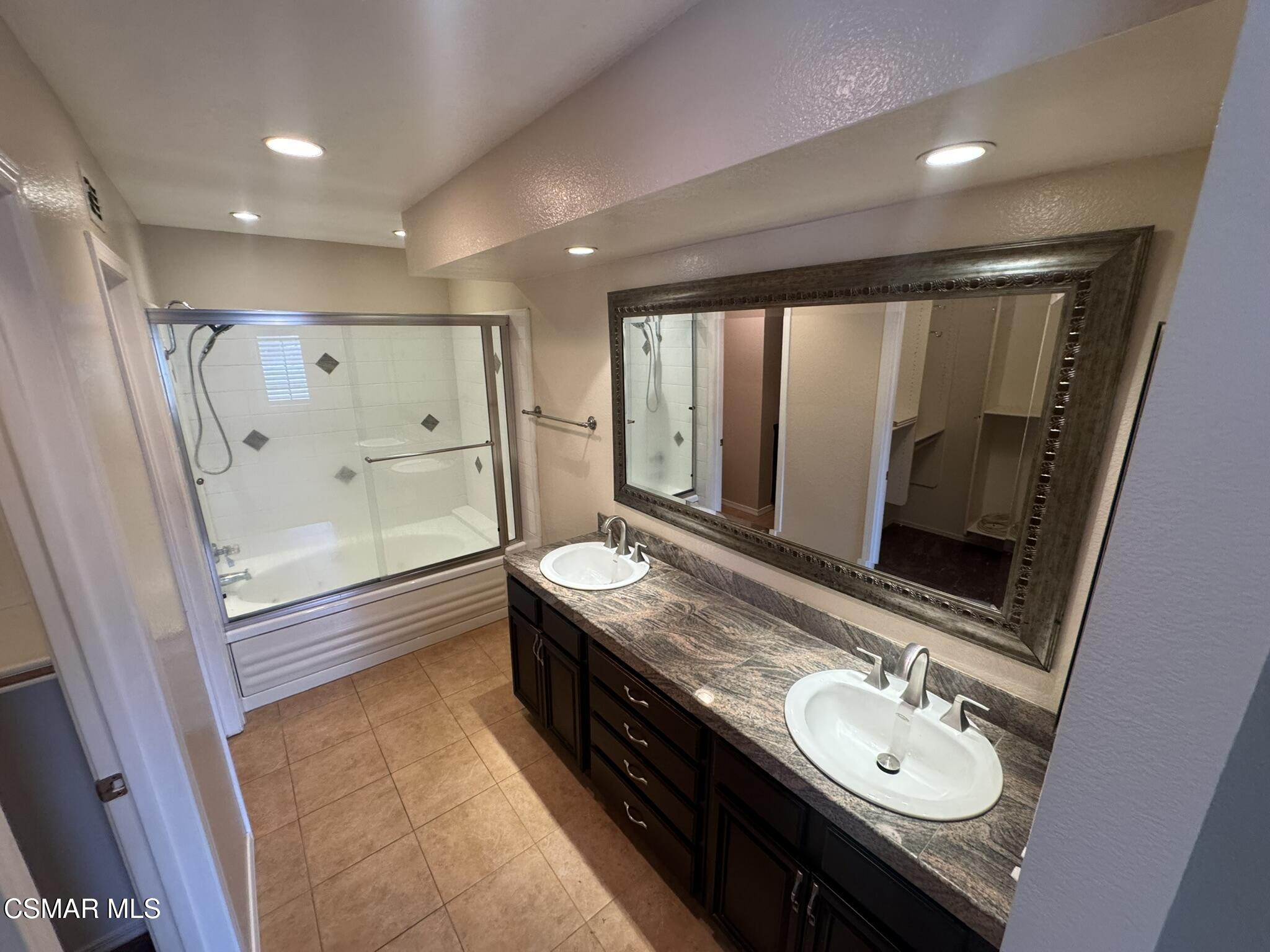 616 Cartpath Place Simi Valley, CA 93065 - Photo 9 of 17 a bathroom with a granite countertop sink a mirror a bathtub and shower