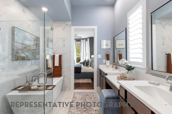 a en suite bathroom with a double vanity sink a mirror and a shower