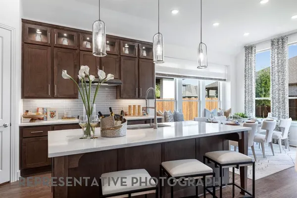 a kitchen with granite countertop a table chairs stove and cabinets