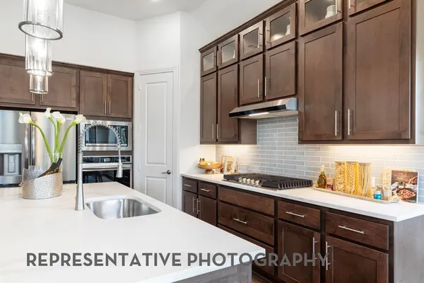 a kitchen with stainless steel appliances a sink a stove and cabinets