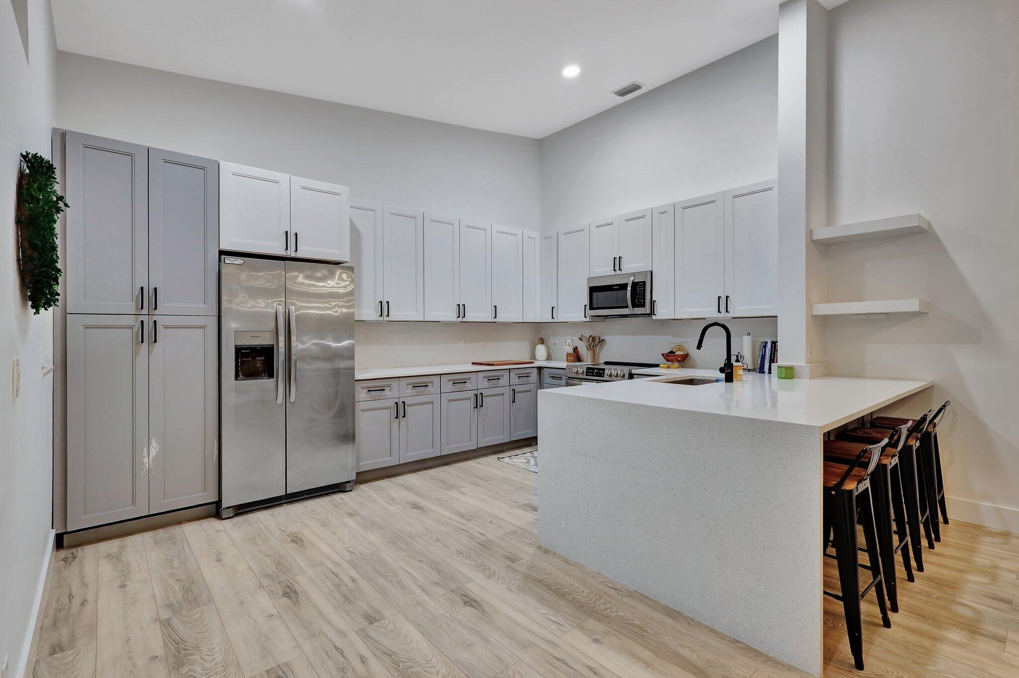 13851 Oneida Drive, Unit B2 Delray Beach, FL 33446 - Photo 2 of 30 a kitchen with stainless steel appliances a sink a stove a refrigerator and cabinets