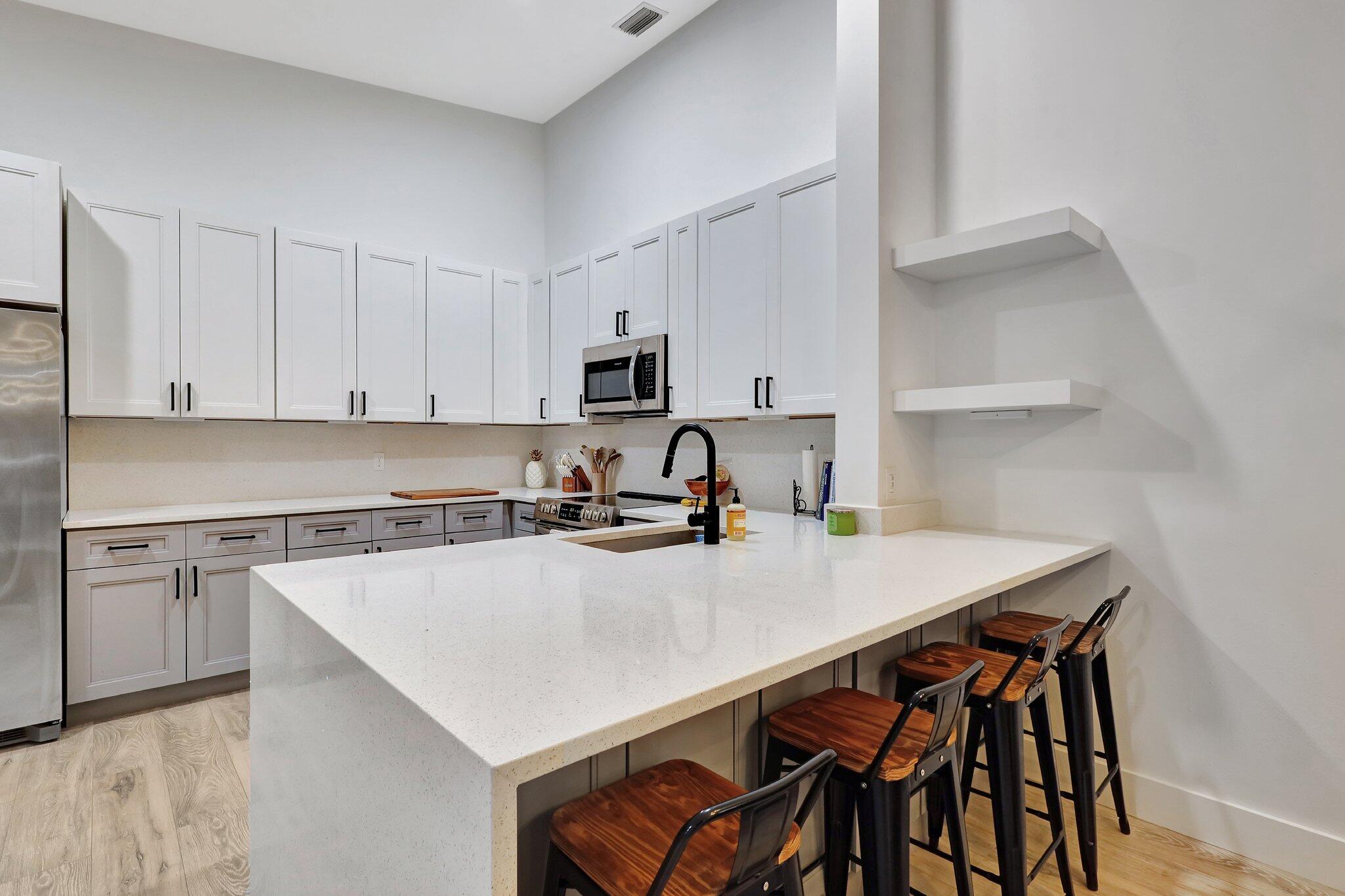 13851 Oneida Drive, Unit B2 Delray Beach, FL 33446 - Photo 3 of 30 a kitchen with a table chairs and a stove top oven