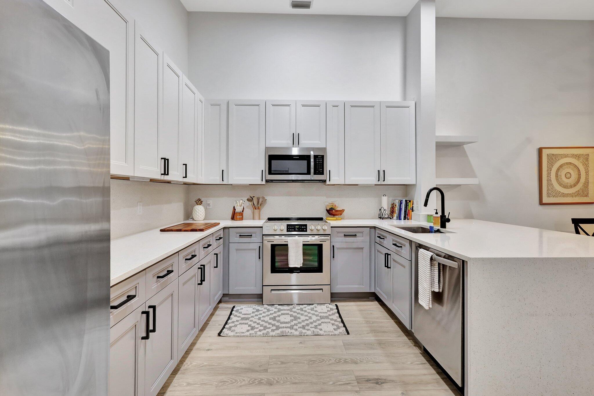 13851 Oneida Drive, Unit B2 Delray Beach, FL 33446 - Photo 4 of 30 a kitchen with stainless steel appliances granite countertop a stove top oven a sink and dishwasher