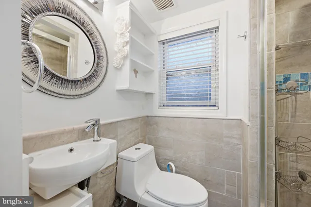 a bathroom with a sink a toilet and a mirror