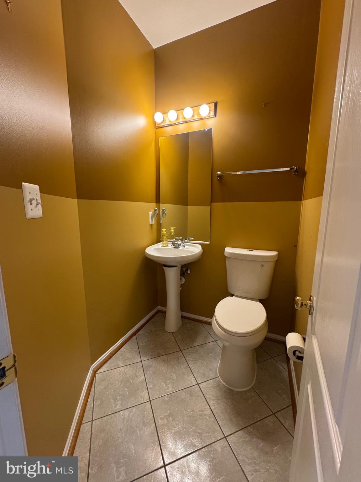7705 Periwinkle Way, Unit 71 Severn, MD 21144 - Photo 13 of 28 a bathroom with a toilet sink and mirror