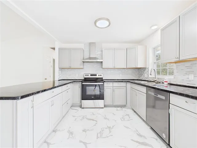a kitchen with granite countertop white cabinets and white appliances