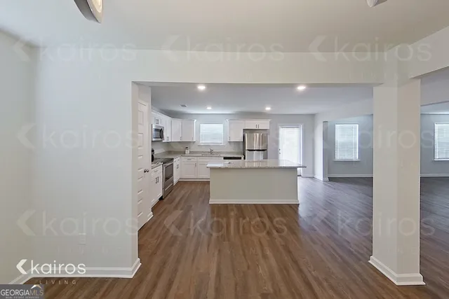 a large kitchen with a wooden floor and a large window