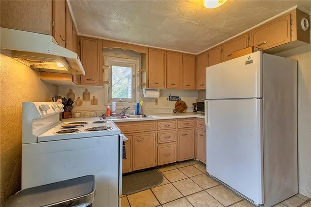 a kitchen with a refrigerator sink and cabinets