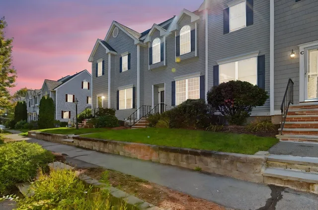 a front view of a house with garden and trees