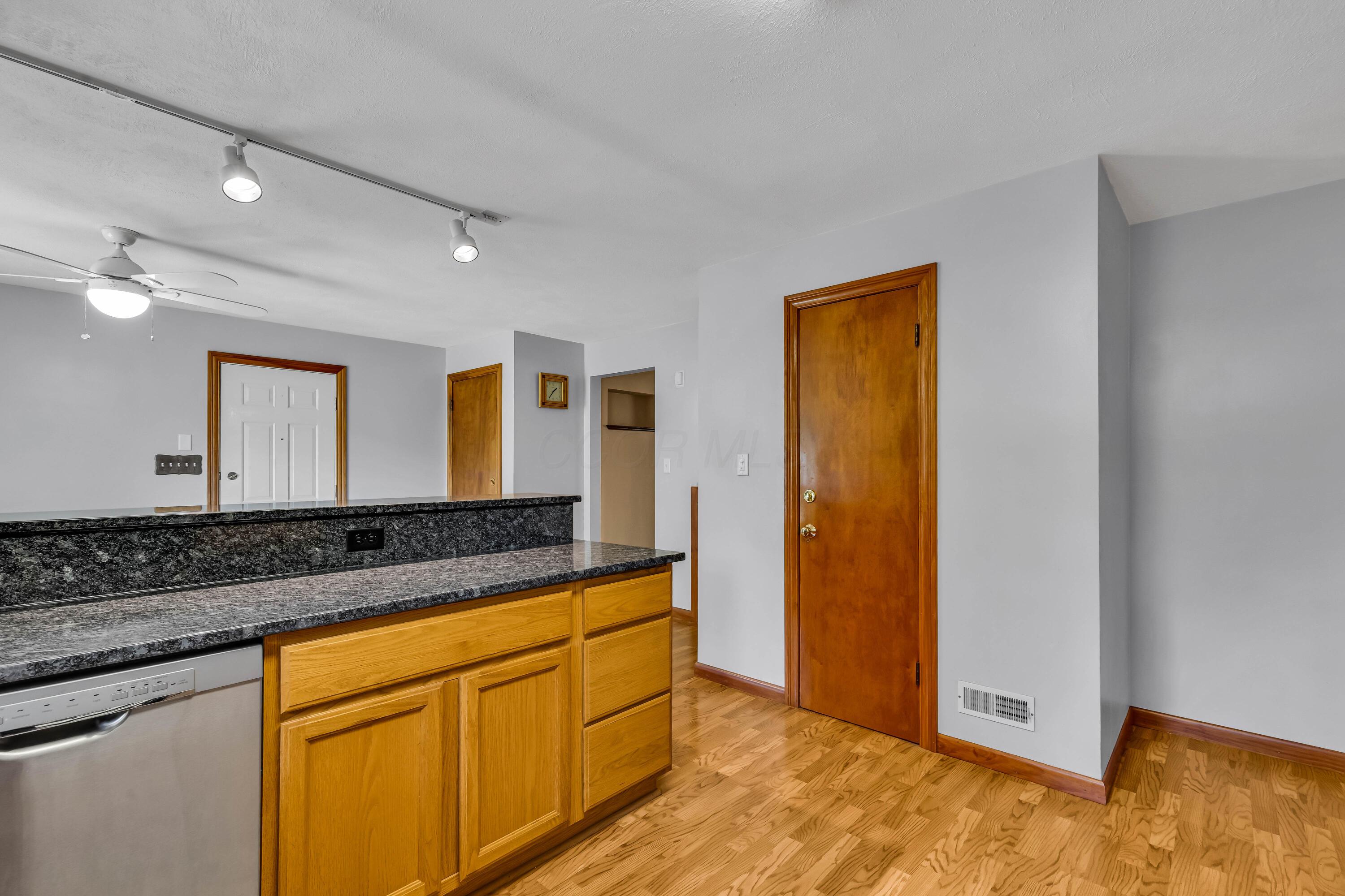 1213 East Cooke Road Columbus, OH 43224 - Photo 23 of 57 • Laminate flooring • Tan painted walls • Oak cabinets • New granite countertops ~ 2020 • Breakfast bar ledge • Track lighting • Kenmore® refrigerator • Tappan® microwave • General Electric® gas stove • New General Electric dishwasher ~ 2020 • Insinkerator® disposal • Glass tile backsplash • Single bowl, stainless steel sink with soap dispenser • Ceiling light • Pantry closet