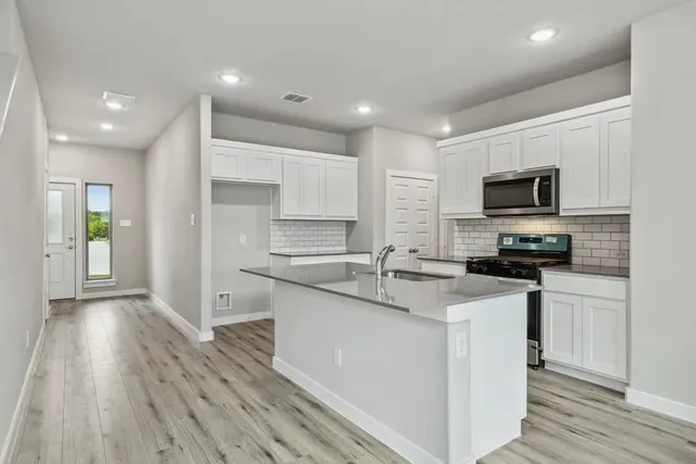 a kitchen with granite countertop a sink and a stove top oven