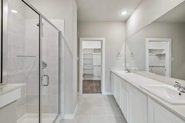 a bathroom with a double vanity sink mirror and shower