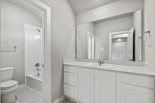 a bathroom with a granite countertop sink a toilet and a mirror