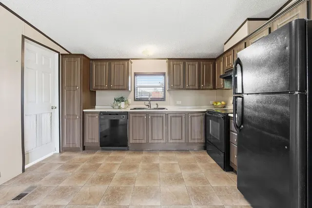 a kitchen with stainless steel appliances granite countertop a refrigerator sink and cabinets
