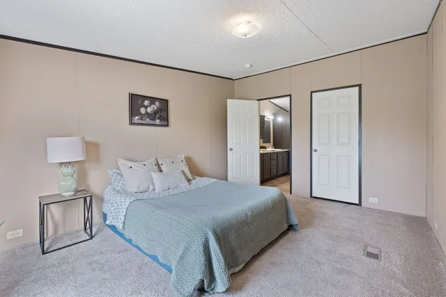 a bedroom with a bed and a refrigerator